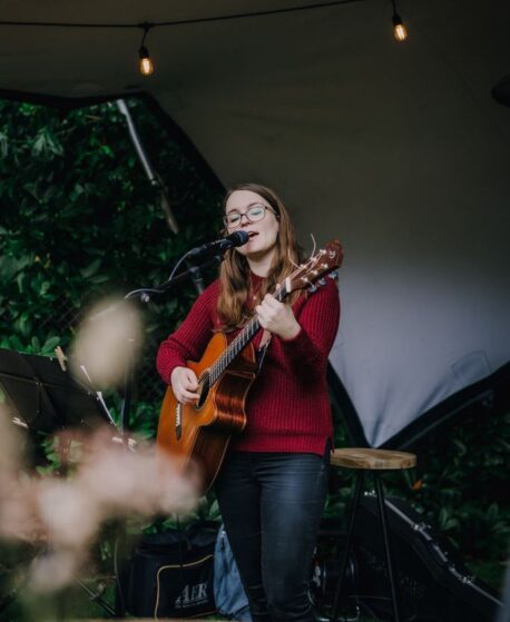 Hannah Stienen singt im Herbst bei einer Garten-Zelthochzeit während des Kaffeetrinkens.