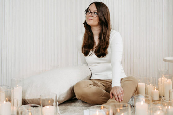 Sängerin Hannah Stienen sitzt in einem Kerzenmeer bei dem Videodreh für ihr Lied für Sternenkinder.