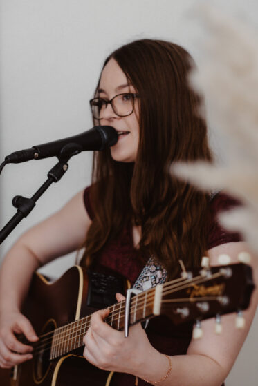 Sängerin Hannah Stienen singt zum Hochzeitstanz und spielt Gitarre.
