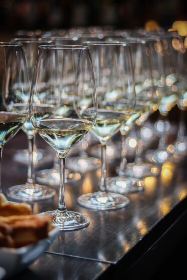 Das Bild zeigt eine Reihe Wein-Gläser zum Wein-Tasting als Aktivität für Weihnachtsfeiern.