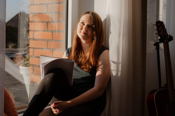 Hannah Stienen sitzt auf der Fensterbank und denkt darüber nach, worüber sie einen Song schreiben möchte.