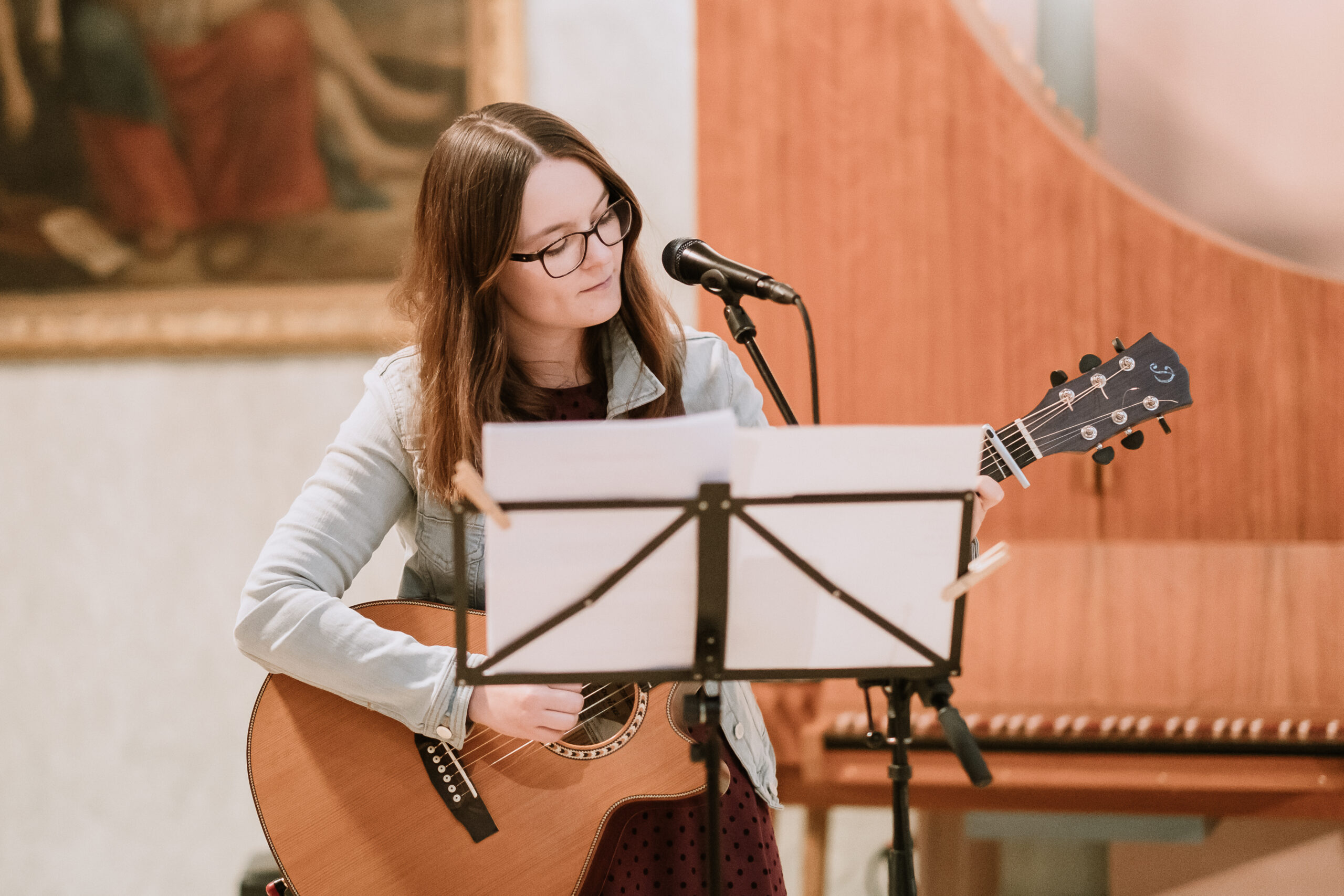 Bild von Hannah Stienen als Hochzeitssängerin in NRW, wie sie live in einer Kirche singt und sich auf der Gitarre begleitet.